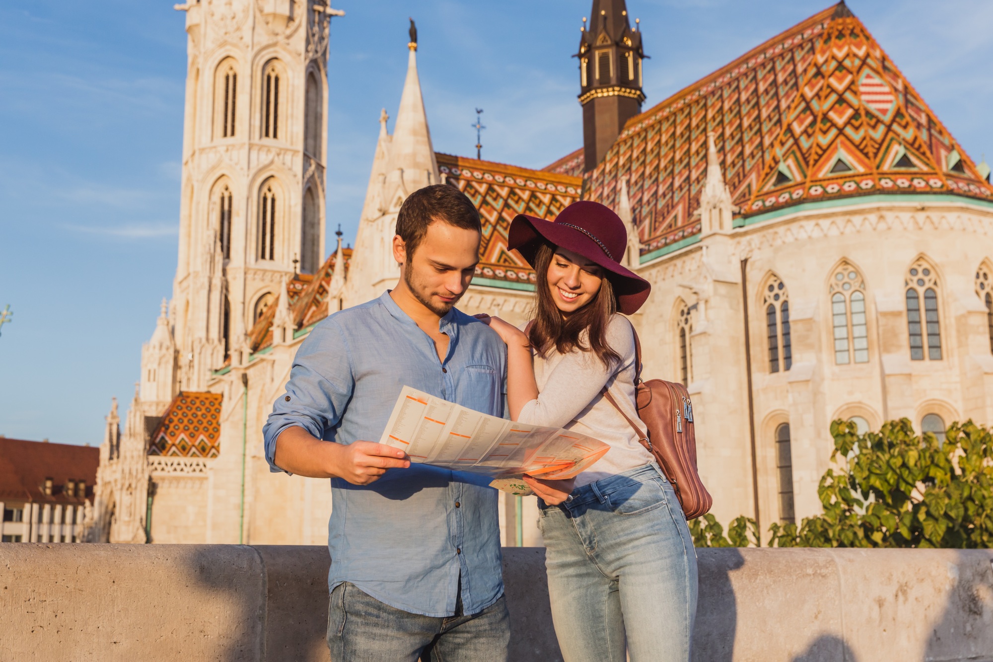 Young couple searching right direction on map from the point from Fisherman Bastion in Budapest with